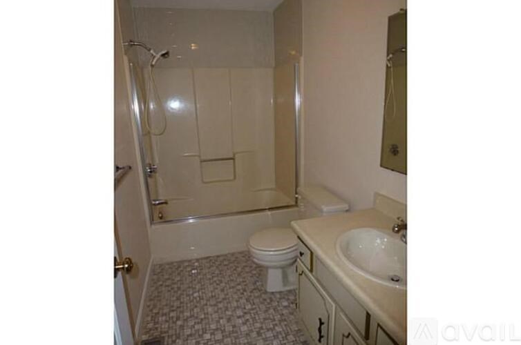 A bathroom with a toilet, sink, and shower.