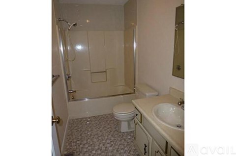 A bathroom with a toilet, sink, and shower.