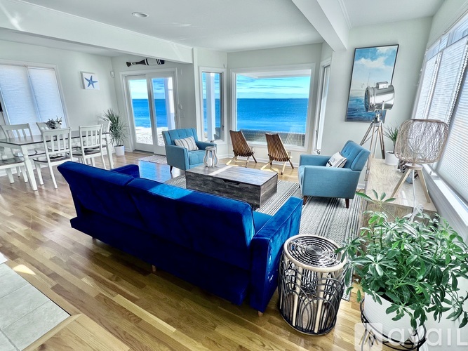 A living room with a view of the ocean through the windows.
