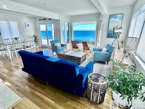A living room with a view of the ocean through the windows.