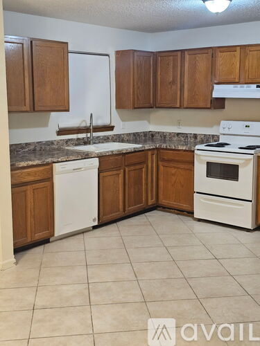 A kitchen with wooden cabinets and white appliances.