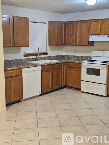 A kitchen with wooden cabinets and white appliances.
