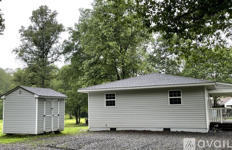 Two houses are situated in a grassy area with trees in the background.