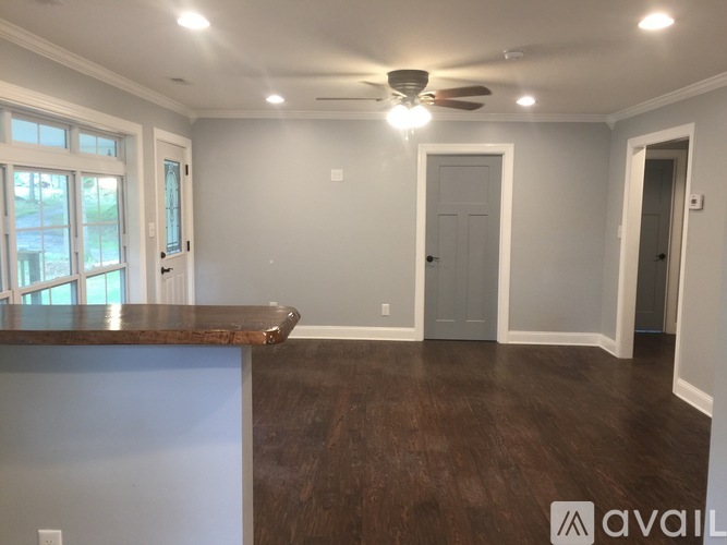 A spacious room with a ceiling fan and a countertop.