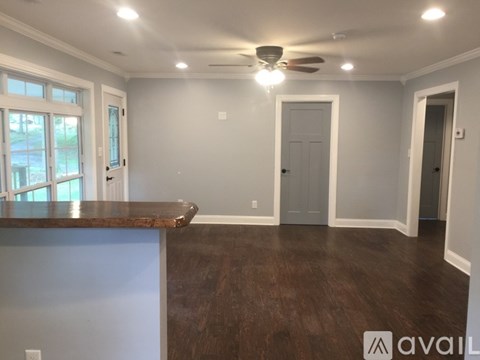 A spacious room with a ceiling fan and a countertop.
