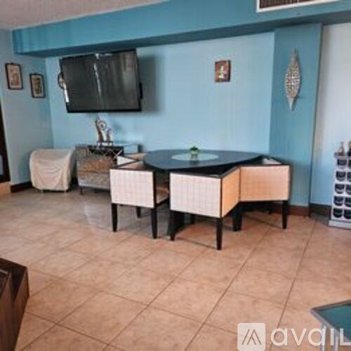 A living room with a black table and white chairs.
