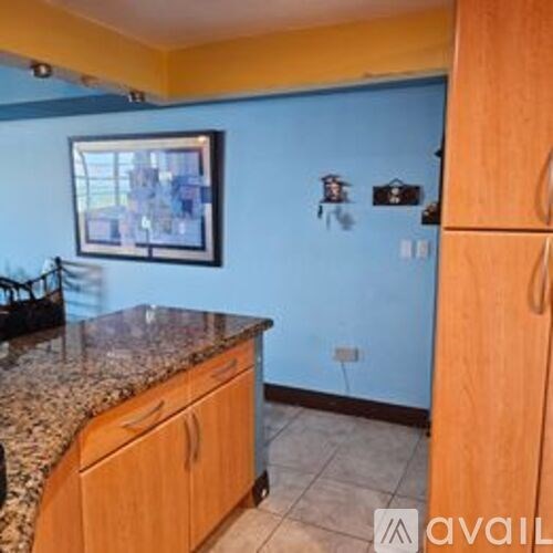 A kitchen with wooden cabinets and a granite countertop.