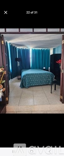 A bedroom with a bed and a chair.