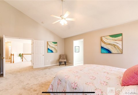 A bedroom with a large bed and a painting on the wall.