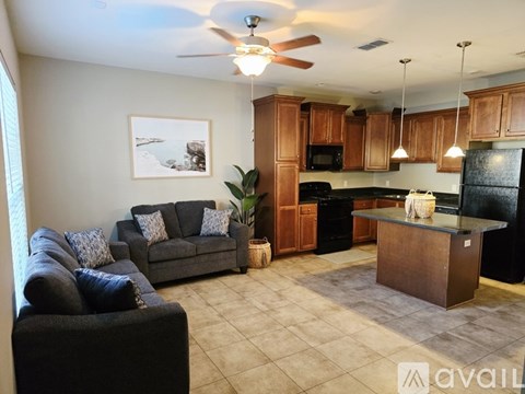 A living room with a grey couch and a black chair.