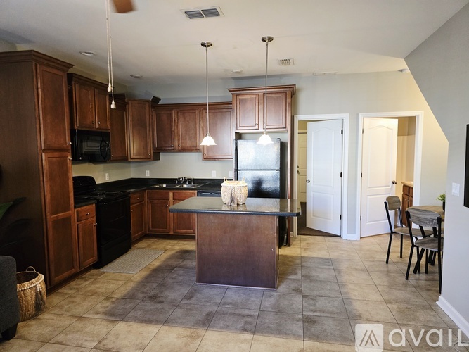 A kitchen with wooden cabinets and a black refrigerator.