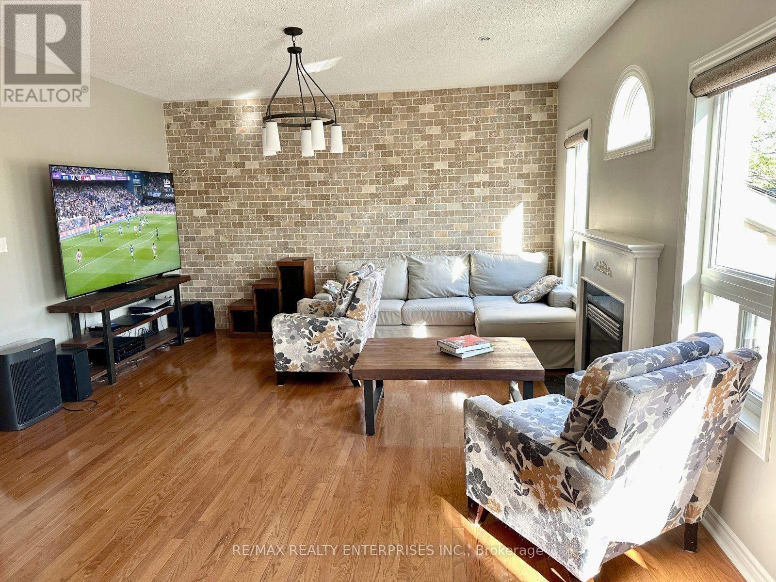 A living room with a brick wall and a television playing a soccer game.