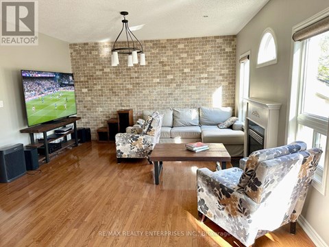 A living room with a brick wall and a television playing a soccer game.