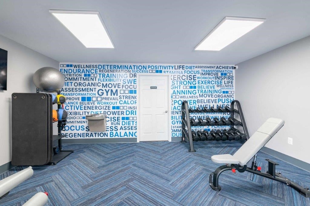 a workout room in a gym with a wall of gym equipment