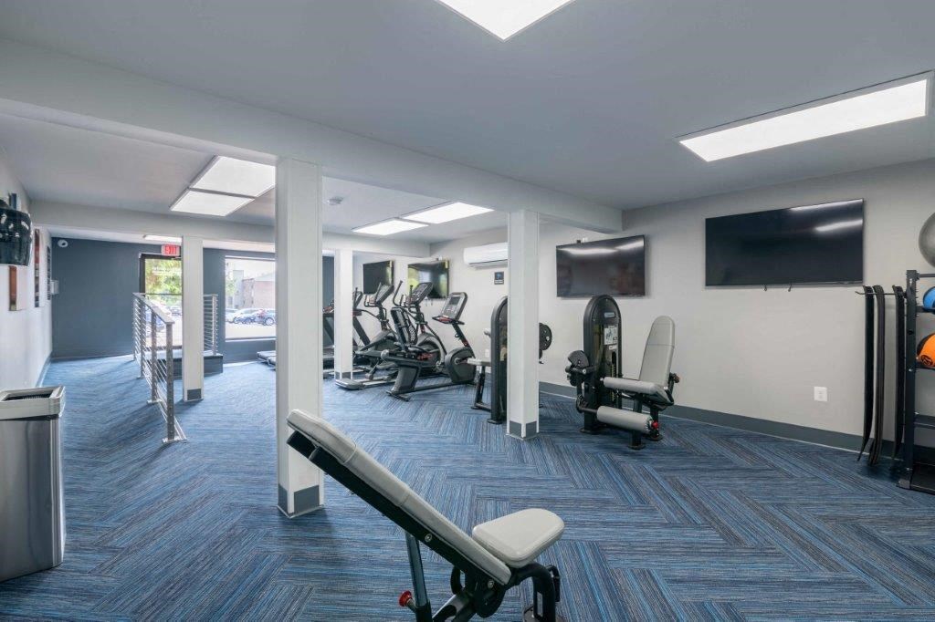 a gym with weights and a tv on the wall