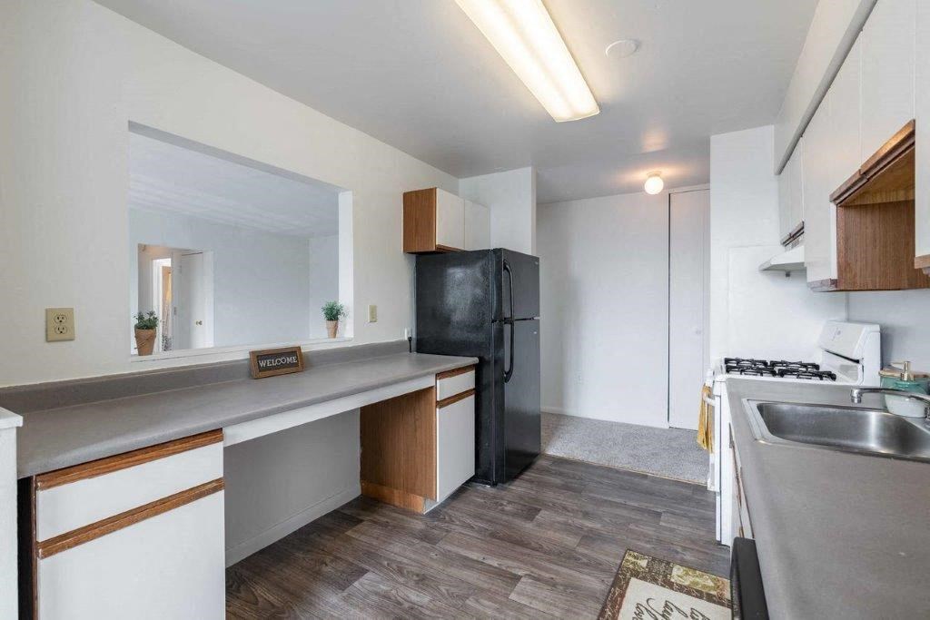 a kitchen with a stainless steel refrigerator and a sink