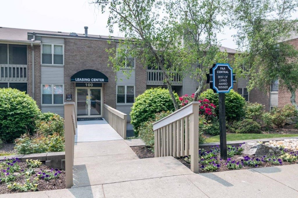a building with a sidewalk and a blue sign in front of it