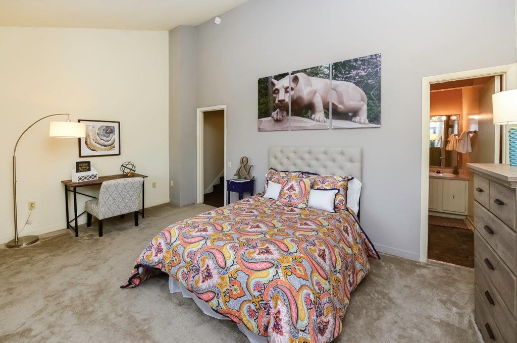 a bedroom with a bed and a desk and a mirror