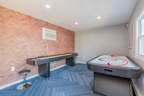 a game room with a shuffleboard table and a pool table