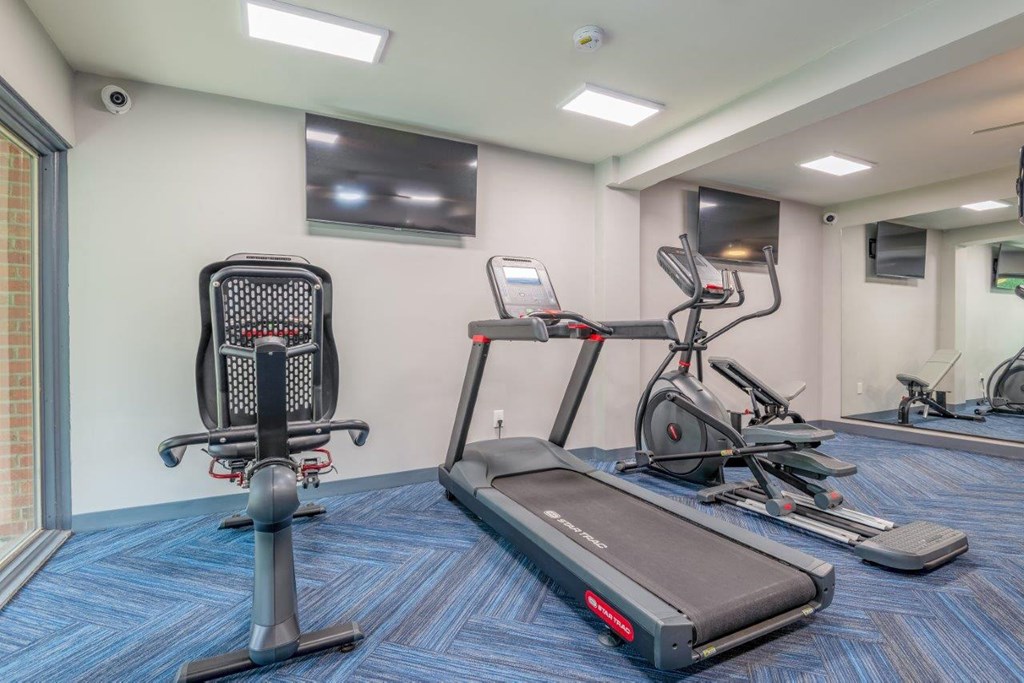 a gym with exercise equipment and a television
