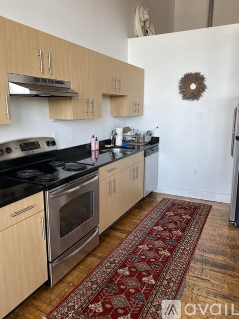 A kitchen with wooden cabinets and a black stove top.