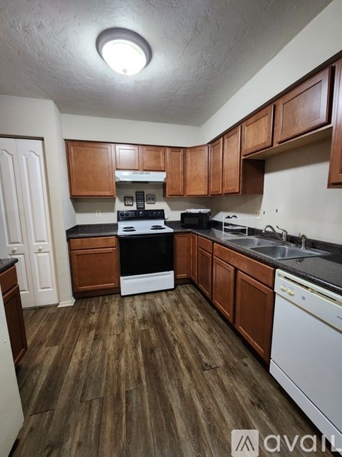 A kitchen with wooden cabinets and a white dishwasher.