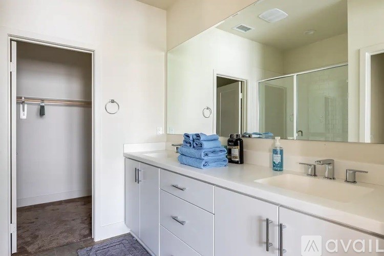 A bathroom with a sink, mirror, and towel rack.