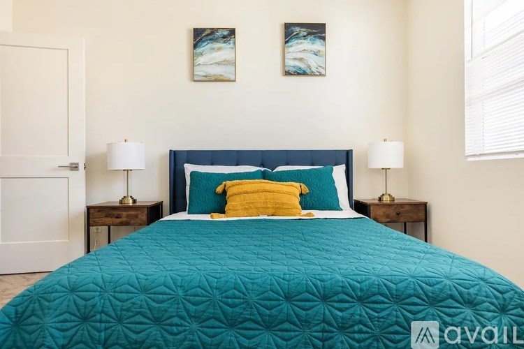 A bed with a blue comforter and a yellow pillow is in the image.