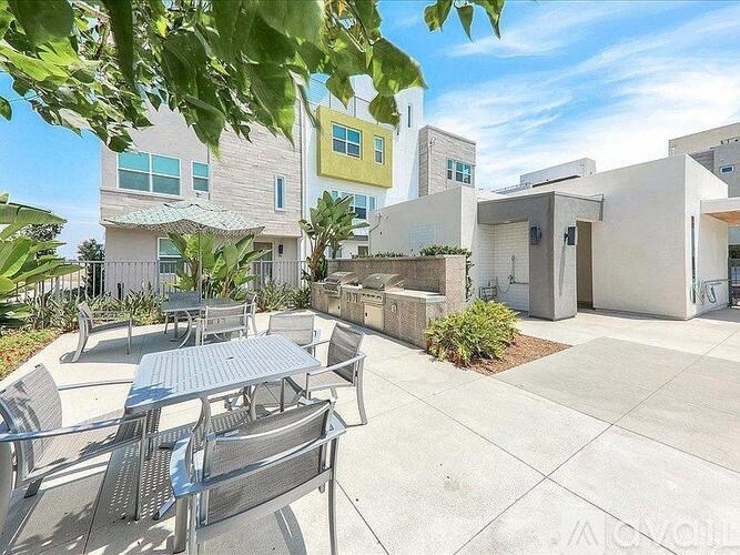 A patio with a table and chairs is surrounded by buildings.