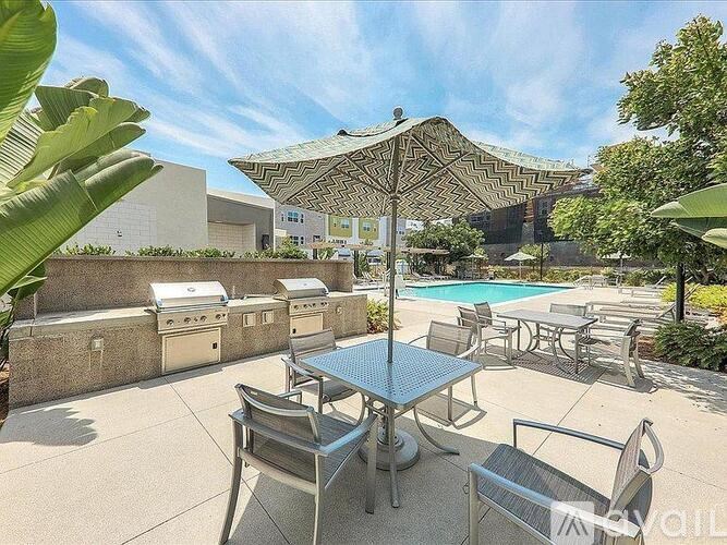 A patio with a table and chairs and a pool in the background.