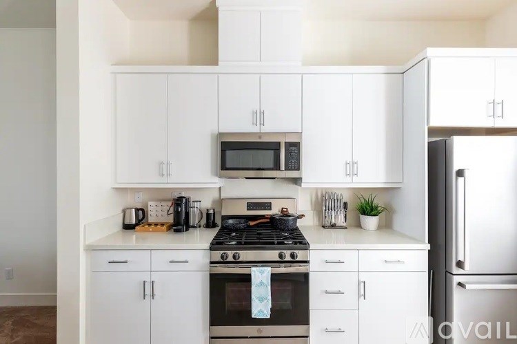 A kitchen with white cabinets and appliances.