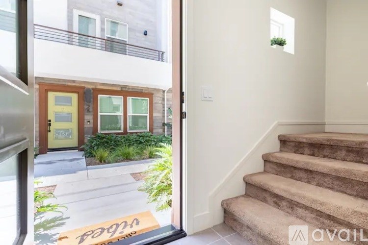 A staircase leads to a brightly lit room with a window.