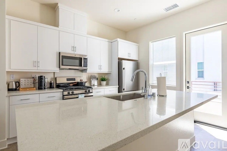 A modern kitchen with white cabinets and appliances.