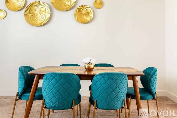 A dining table with four chairs and a wall decoration.