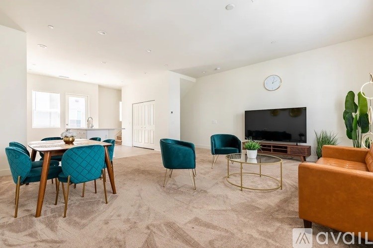 A living room with a television, a dining table with chairs, and a sofa.