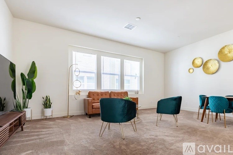 A living room with a brown sofa, a green chair, and a wooden table.
