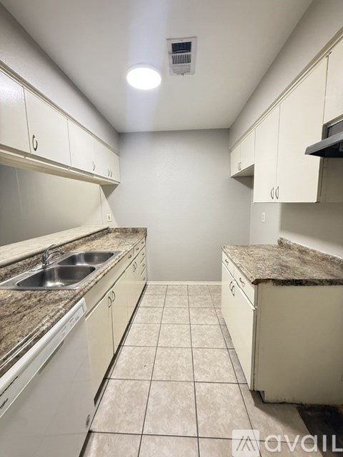 A kitchen with white cabinets and a granite countertop.