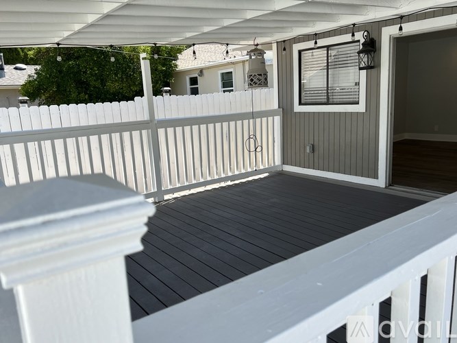 A white fence and railing on a wooden deck.