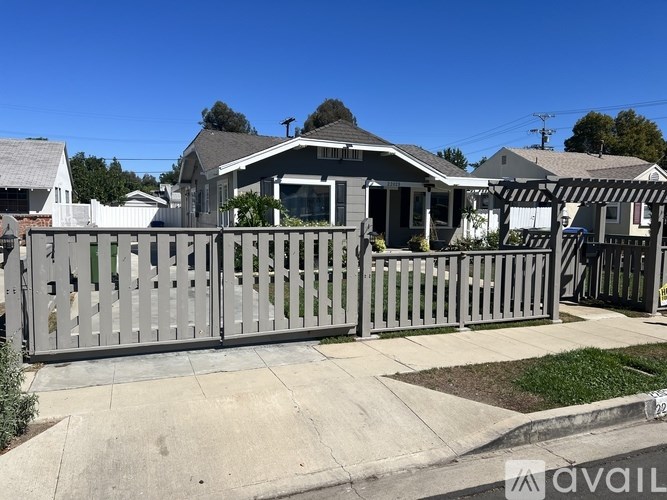 A house with a grey fence is available for sale.