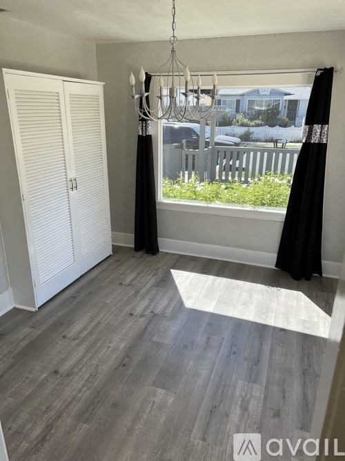 A room with a white door and a grey floor.