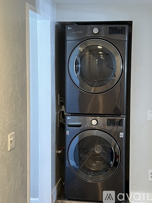 A stack of two front loading washing machines in a laundry room.