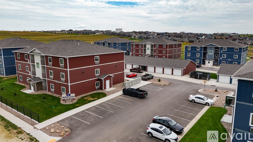 A parking lot with cars and apartment buildings.