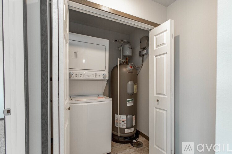 A small, white, built-in refrigerator and freezer are in a kitchen pantry.