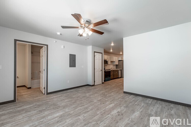A spacious room with a ceiling fan and lighting fixtures.