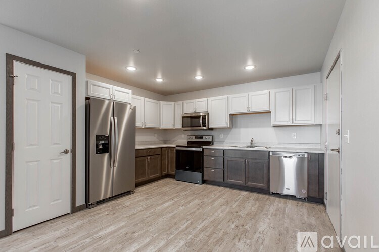 A kitchen with a refrigerator, oven, and sink.