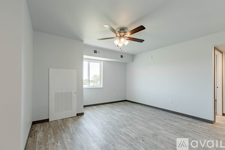 A room with a ceiling fan and a window.