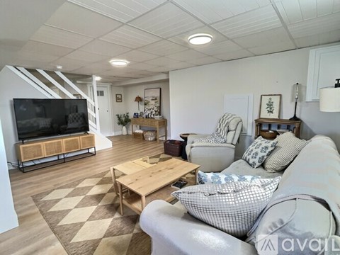 A living room with a grey couch and a wooden coffee table.