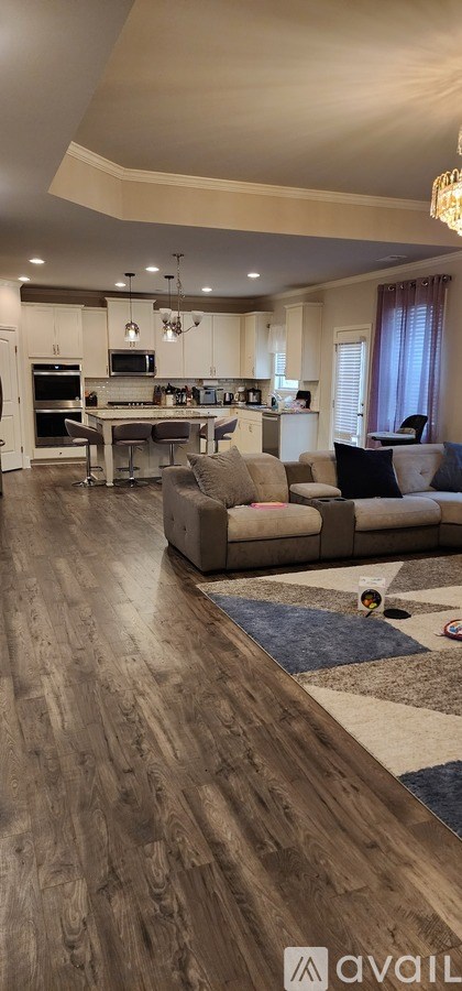 A modern living room with a grey couch and a wooden floor.
