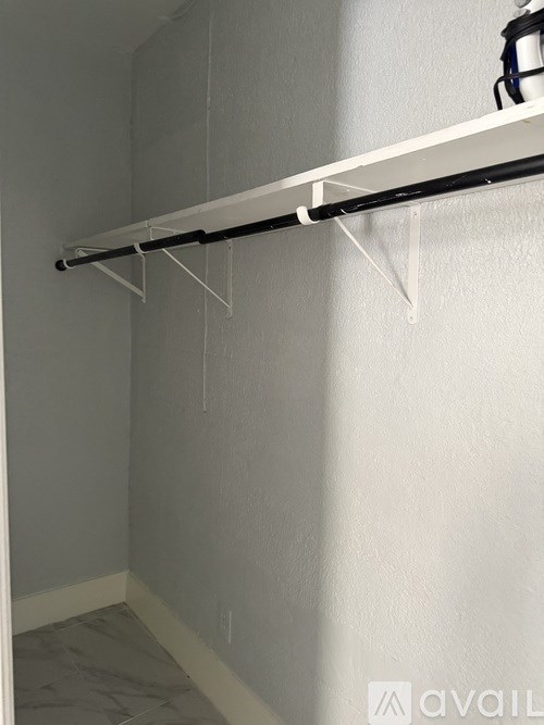 A white shelf is mounted on a wall.