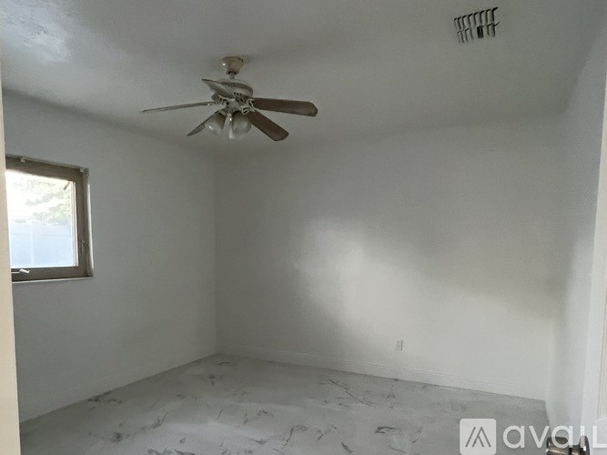 A room with a ceiling fan and a window.